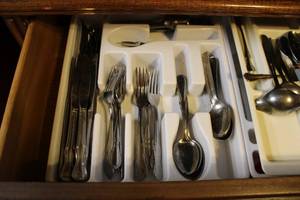 lot 43 image: Contents of Drawer MISC Silverware, Cross-stitched Dining Linens
