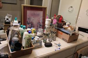 lot 204 image: Bathroom counter contents wire racks, glass cannisters, artwork, lotions, small Kodak camera
