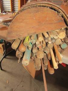 lot 46 image: Wooden barrel full of old broom and mop sticks Barrell is falling apart, believed to be used for dcor