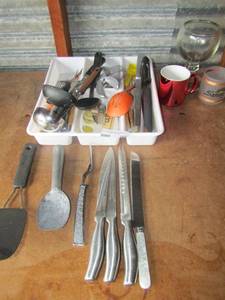 lot 105 image: white 4 divided silver ware draw holder also comes with various silverware such as stainless steal knives, big spoons, spatchulas, 2 coffee cups one is Santa Fe las vegas 22K gold By Kapamn kent and a margarita glass