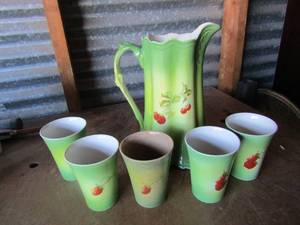lot 155 image: Tea pot and cup set, 10 handled green tea pot with strawberry design, 5 matching cups 1 of wich is discolored