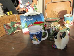 lot 73 image: Christmas lot includes, cups, table place mat, snowman decor mail box, 2 gold star candle stands, 2 angels and more