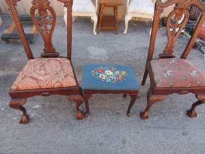 lot 147 image: 2 dark brown high back chairs has 2 different seat patterns one is cracked at top, and a brown wooden stool with blue floral dcor seat pattern