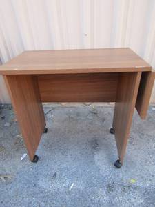 lot 168 image: Brown rolling microwave table with one folded side, used in good condition, size 262716, 1 side that folds is 10 so it is 263716 with folded side out