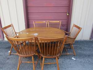 lot 1 image: Light brown oval dining table with fold down sides, comes with 2 captain chairs and 4 side chairs--- 295454 with sides up, each side is 13 per  ( x $$)
