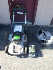 lot 2 image: E-Go 56V Power self propelled electric lawn mower, comes with battery and charger all works great, also has a bag to catch the grass, PREOWNED -(New price 599.00)  comes with paper work