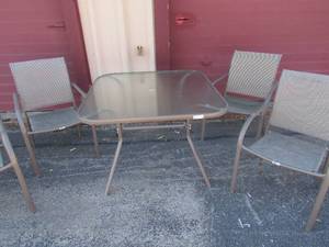 lot 30 image: Glass top outdoor patio table with 4 chairs, very nice condition like new, table size 284242, has a place for a umbrella (not included)