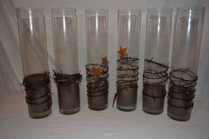 lot 102 image: (6) Mixed Clear Glass Vases - 4W x 18 Tall with coffee grounds as shown