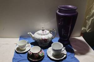 lot 23 image: Musical Tea Pot, 3 China Tea Cups and Saucers, and Purple Asian Etched Tall Glass Vase Made in Spain (approximately 24 inches tall)