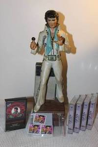 lot 104 image: Vintage Elvis Presely Decanter and Music box and other memorbila Items, including 3 Elvis Presely Stamps, Elvis Presely Christmas cassette, 4 other Rock and Roll  Cassettes (CHARLIE NOT INCLUDED)