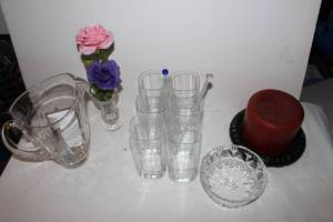 lot 94 image: Glassware and home Dcor Items, 6 Crystal glasses, Shannon Crystal Pitcher, 2 Crystal Stir Sticks  Large Pillar Candle on Wooden Pedestal, Small Crystal Vase with Flowers