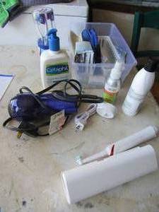 lot 60 image: Used and new lot of bathroom items, includes tooth brushes with electric charge, lotions, hair dryer, soap and soap dish and more