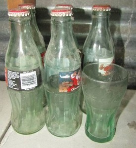 lot 115 image: 5 Christmas of 1996 coca cola classic soda pop bottles un opened, and a small coca cola drinking glass