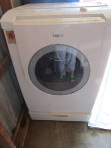 lot 12 image: Bosch front load washer with 6 settings 500 nexxt series, front glass needs replaced has a small crack, worked when we received, also has bottom storage