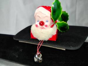 lot 106 image: Santa Claus lite-up lapel pin - Late 1950s - early 1960s Aladdin Products. Currently inoperable. 1.5 x 2. When you pull the bell string, Santas nose is supposed to light up.
