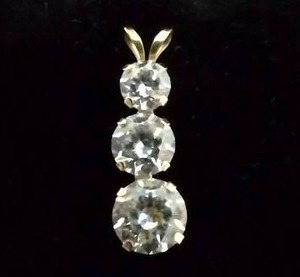 lot 118 image: 14K yellow gold Past, Present, Future graduated CZ pendant. Marked JCM 14K. 1.0 gr approx.