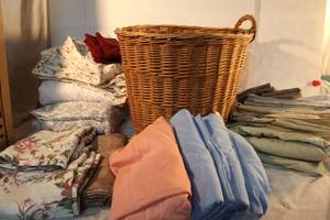 lot 131 image: Basket with linens, bed sheets and curtains