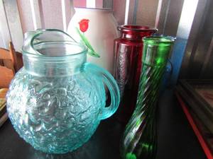lot 40 image: handled blue glass water pitcher,9 in red flower vase, 9in green vase, 8in blue vase, 10 in red rose vase