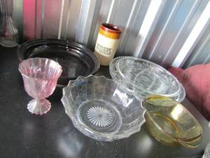 lot 56 image: 11in world market black pie plate cracked from one side to the other has been glued together, 14in star david oval platter has 2 breaks at the top, various other bowls, kitchen utensails holded