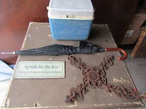 lot 126 image: rubbermade lunch box, black umbrellea, 24x19 cast iron cross bent on one end, 12 x 5 agenda of the day sign