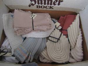 lot 138 image: box of different color napkins, hand knitted plate matts, and Christmas and animal plate matts