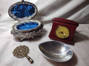 lot 120 image: Jewelry S & W spelter velvet lined hinged dresser box with floral motif. Also includes a MCM Nambe 523 dish (marked), a Vintage Florn travel alarm clock (1930-1969) and Persian style shade finial.
