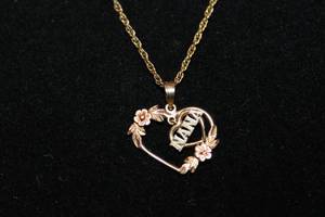 lot 207 image: Jewelry 10K Gold 10K yellow gold Nana dangle pendant in heart form. Marked 10K. Presented on a gold tone 18L necklace. 0.8 gr approx. (Pendant only)