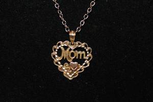 lot 206 image: Jewelry 14K Gold 14K yellow gold MOM pendant in heart form. Marked 14K OR. Presented on a gold tone 18L necklace. 1.3 gr approx. (Pendant only)
