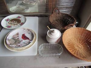 lot 87 image: Decretive plates, 2 wicker baskets, large white cutting board, honey pot, covered clear glass dish