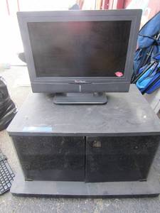 lot 60 image: View sonic 20 older tv, also comes with a rolling tv table with bottom storage for movies and suchhas dB front glass doors at bottom