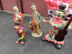 lot 125 image: Clown 7 playing the cello,  wooden clown,  ceramic clown with a cane,  ceramic clown with a umberella