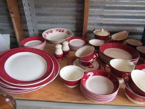 lot 47 image: New set of red and white dishes, 9 handled cups and 9 cup saucers, 6 desert dish, creamer and sugar- salt and pepper, 2 oval platters, 4 dinner plates, 6 salad bowls, 6 bread saucers, gravy boat