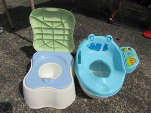 lot 195 image: childs potty qty 2 one is a lion and the 2nd is a saftey first potty both used, needs wiped down