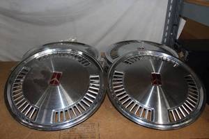 lot 82 image: Two Sets of 4 New old Stock Olds Hubcaps