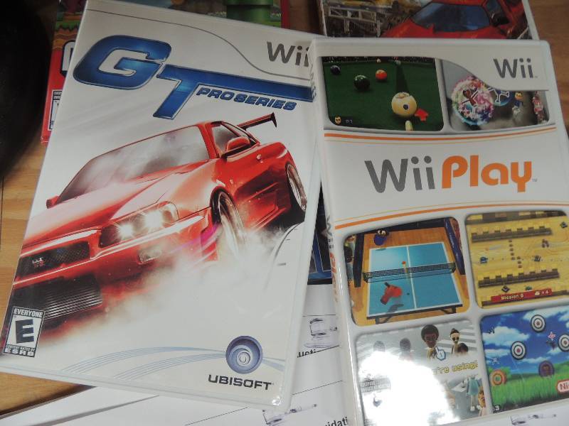 lot 254 image: 2 Wii steering wheels and 4 Wii gam...WII PLAY, GT PRO SERIES, MONSTER 4X4, SUPER MARIO BROTHERS