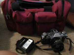 lot 236 image: Canon AE-1 camera with a red carrying case
