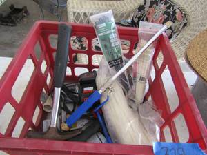 lot 329 image: red crate full of misc. tool like zip ties, hammer, battery charger, extension cords and more