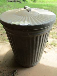 lot 834 image: metal out door trash can with lid, also has a yellow gas can in it