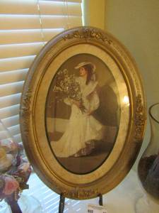 lot 82 image: framed photo on stand of a women in her wedding dress size 23x16, 16  vase with coffee beans and a candle and a glass oil lamp with angel size 18 inches tall