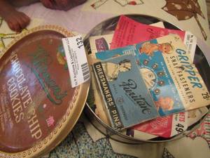 lot 132 image: chocolate chip cookie tin can with brass dress makers pins, gripper snap fasteners and more