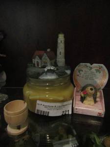 lot 221 image: orange vanilla candle with light house lid, small headboard ceramic and more