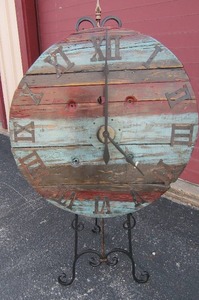 lot 1 image: Wooden Clock  36 diameter  (TEALREDBROWN S) on metal stand  very nice and works just needs new batteries 60 x 22