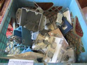 lot 26 image: blue crate of electric switches, outlets and plates