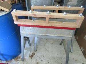 lot 175 image: 2 metal saw horses both have wooden top with rollers on them