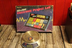 lot 252 image: Vintage 60 in 1 project Lab, a set of postal or Kitchen scales and a six flags Golf tournament Coin