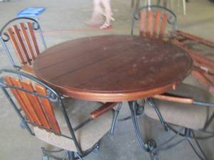 lot 265 image: Oval maple wood dining table 29 H x 48 diameter has metal curved legs, 4 rolling dining chairs