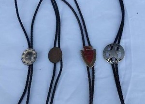 lot 9 image: Nice Selection of 4 Bolo Ties--Texas Rangers marked Fargo Silver, Arrow head with gemstone, Lucky Buddha, and Silver looking one