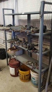 lot 86 image: Industrial Metal Shelf w Contents.  Lathe Bar Stock, tension Bolts, Tow Hook & More