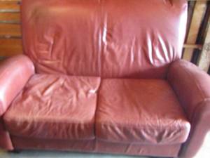 lot 34 image: Red love seat , no brand has minor scratches from what appears to be a cat, unsure