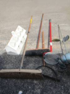 lot 108 image: Yard tools- pecan picker- brooms- scrapper- metal yard dcor and bird house